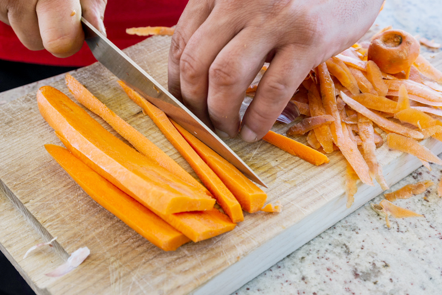 hands chopping carrots