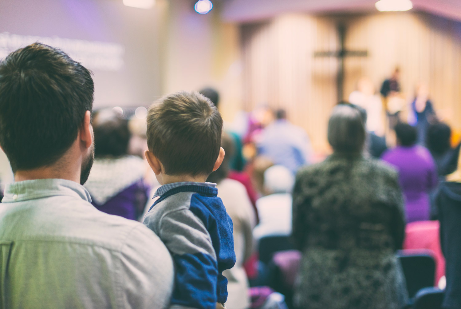 Man and child participating in worship service